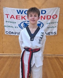Jakob Dinning-Staker proudly holding his World Taekwondo Junior Black Belt